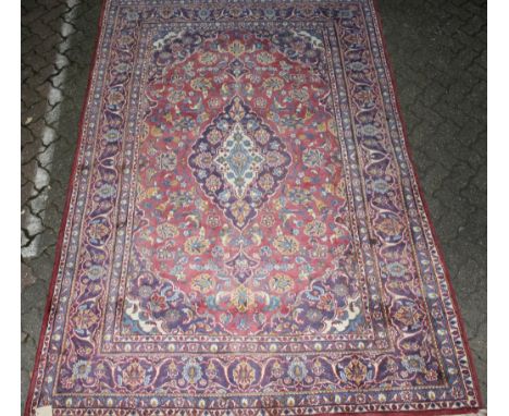 A Kashan carpet, pale pink ground with stylized floral decoration. 9ft 7ins x 6ft 4ins.