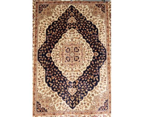 A Kum carpet, beige ground with stylized floral decoration. 9ft 2ins x 6ft 6ins.