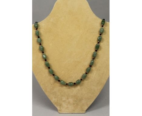 A GREEN JADE AND RED STONE NECKLACE.