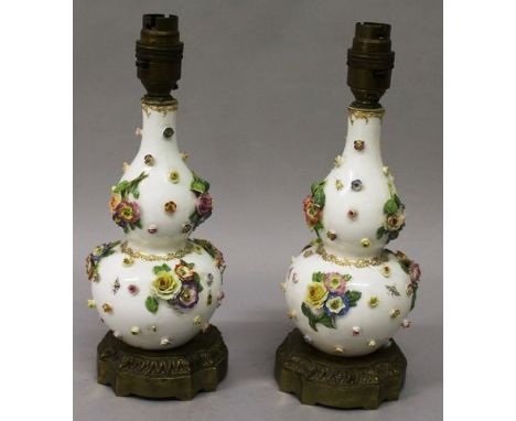 A GOOD PAIR OF DRESDEN DOUBLE BOTTLE VASES edged in gilt and encrusted with flowers on ormolu bases.  Converted to electricit