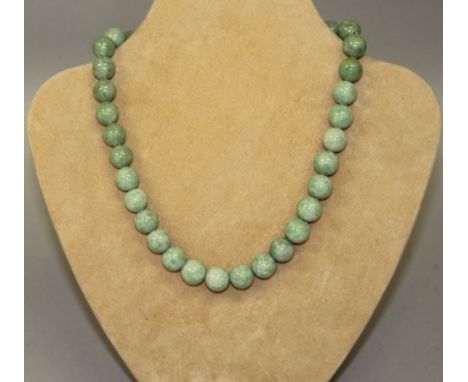 A GREEN JADE NECKLACE.