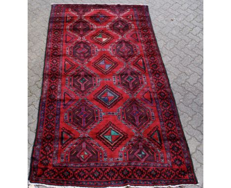 A Hamadan carpet, claret ground with three rows of diamond shaped medallions within a similar border. 9ft 8ins x 5ft 2ins.