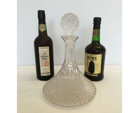 A pressed glass ships decanter together with 2 bottles of Port. A Cockburns 10 year old Tawny Port and a Sandeman fine Tawny 