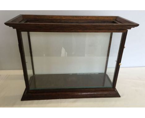 A small oak display cabinet with glass shelf. 46cm wide by 38cm high.