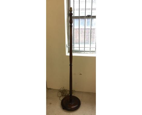 A mahogany standard lamp with round base.
