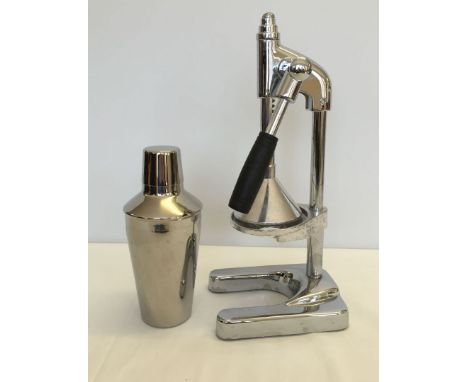 A chrome lemon squeezer and a cocktail shaker.