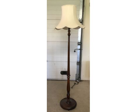 A dark oak decorative standard lamp with a cream shade.