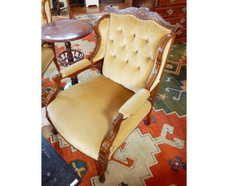 A pair of Edwardian button back armchairs, the crest rail with floral inlay, padded arms, upholstered stuffover seats, on cab
