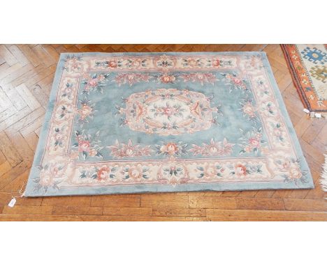 A wool wash Chinese carpet with blue field, floral decoration, 120cm x 185cm and a circular Chinese wool wash rug, floral dec