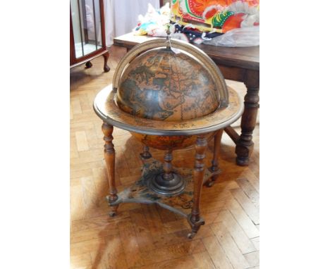 A cocktail cabinet in the form of a terrestrial globe on a stand, the hinged cover opening to reveal fitted interior with a r