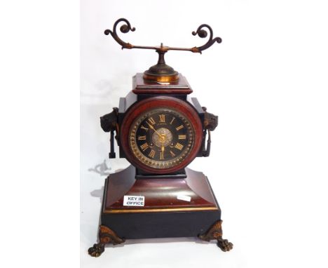 A Victorian red and black marble mantel clock, with ring handles and paw feet, the black dial with gold Roman numerals signed