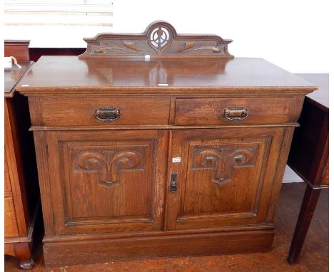 An early Victorian oak sideboard with art nouveau style carving, two frieze drawers with carved panel cupboards below enclosi