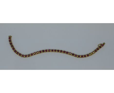 A 9ct gold and ruby bracelet, lacking one stone, 11g