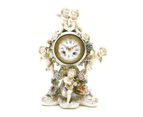 A Continental porcelain mantel clock, the white enamel dial with Roman numerals encompassed within a floral decorated cage wi