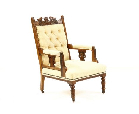 An Edwardian walnut library chair, with pierced arms, carved rail, turned legs and yellow button back upholstery, height 102c