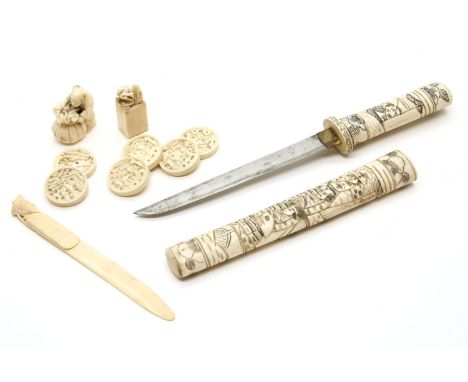 A collection of Chinese ivory carvings, late 19th century, comprising a bookmark topped with a Chinese official, six game cou