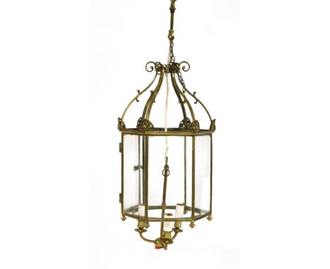 A brass hexagonal and glazed hall lantern, with scrolling bracket supports, early 20th century, 50cm high