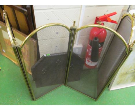 A four panel brass folding firescreen and a small fireback