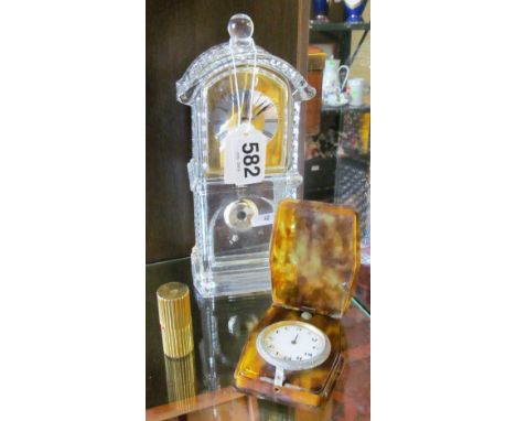 A glass clock and two travelling clocks