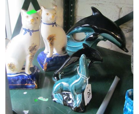 Two Poole Pottery dolphins (one a/f), a Poole Pottery seal and two Staffordshire cats (one a/f)