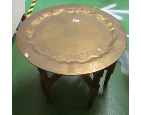 A Middle Eastern brass tray on folding stand