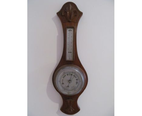 A barometer/thermometer in oak case