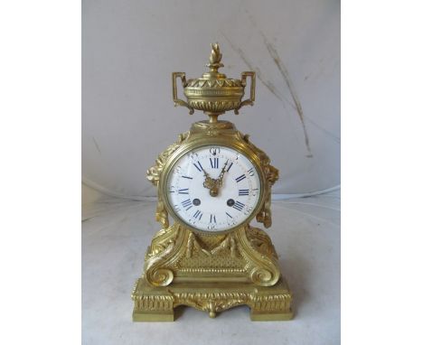 A 19th Century gilt mantel clock with urn finial, white painted dial and scroll front on square feet