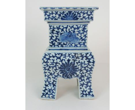 A CHINESE BLUE AND WHITE ARCHAIC STYLE CENSER painted with peonies and reserved on a foliate scroll ground, the rectangular s