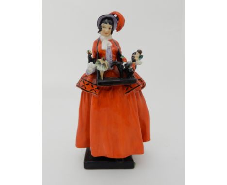 A ROYAL DOULTON FIGURE THE SKETCH GIRL modelled a a girl selling toys, originally produced for The Sketch magazine, designed 