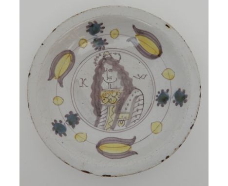 A 17TH CENTURY DUTCH DELFT COMMEMORATIVE DISH circa 1690, painted in puce, yellow and green with a portrait of King William o