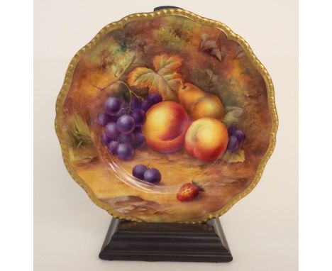 A ROYAL WORCESTER FRUIT DECORATED CABINET PLATE painted with peaches, grapes, pears and strawberries on a mossy background, s