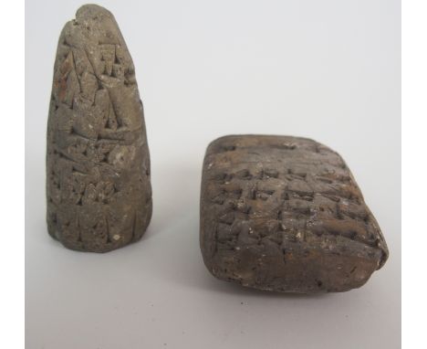 A BABYLONIAN CARVED STONE TABLET with text front and back, 7cm, high and 5cm wide and a cone shaped tablet, 7.5cm high and an