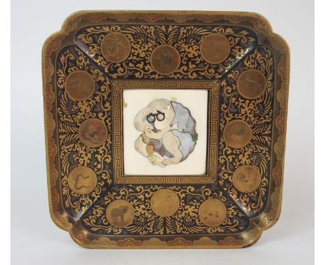 A SHIBIYAMA STYLE SQUARE SHAPED PLAQUE applied in high relief with a crouching monkey with glasses holding a monkey netsuke, 