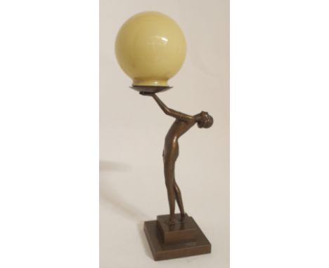 AN ART DECO BRONZED SPELTER LADY LAMP modelled as a semi-clad female holding a bowl which supports the shade, upon square ste
