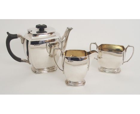 A THREE PIECE SILVER TEA SERVICE by Cooper Brothers &amp; Sons Limited, Sheffield 1962, of rounded rectangular form on steppe