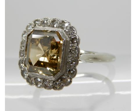 A CHAMPAGNE AND WHITE DIAMOND RING the step cut central diamond is estimated approx 2.3cts and surrounded with approximately 