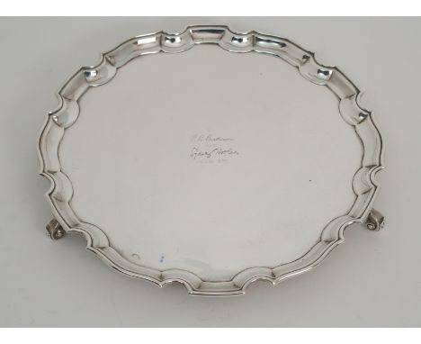 A SILVER SALVER by S Blackensee &amp; Sons Limited, Chester 1930, of circular form with scalloped edge on three scrolling fee