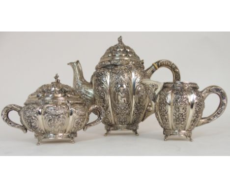 A BACHELOR'S GERMAN SILVER THREE PIECE TEA SERVICE marked on the base 800, the lobed body richly embossed with flower baskets