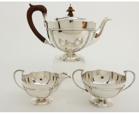 A THREE PIECE SILVER TEA SERVICE by Adie Brothers Limited, Birmingham 1925, of tapering circular form with scrolling handles 