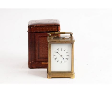 A gilt brass cased carriage clock, the white enamel dial with Roman numerals, complete with leather carry case, 17.5cm high (