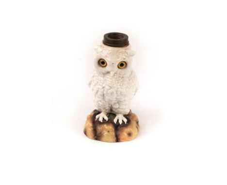 A German ceramic owl lamp base with glass eyes, modelled perched on a rock, 16.5cm high