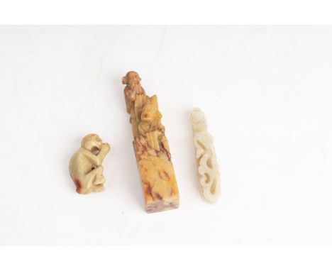 A Chinese jade belt hook, Qing, carved a grotesque mask to the terminal and a kylin, 9cm long and two soapstone carvings COND