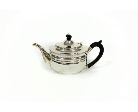 A silver teapot, London 1911, of oval shape with ebonised finial and handle, approximately 560gm gross
