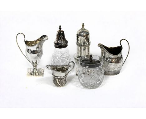 A George III silver cream jug, London 1799, of helmet shape, two further jugs, a silver caster, a silver mounted glass caster