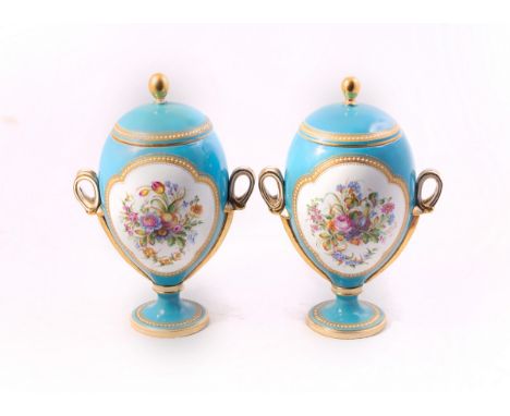 A pair of ovoid porcelain vases and covers, circa 1860, each with panels of flowers within jewelled gilt borders to a turquoi