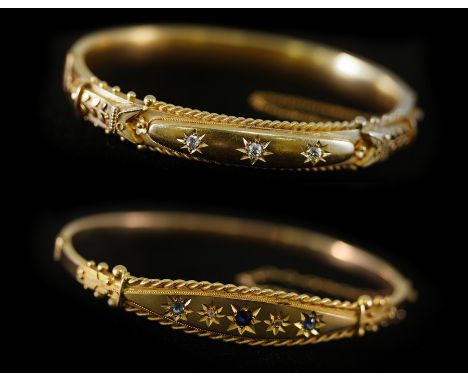 A 15ct yellow gold hinged bangle, circa 1912, set with three diamonds, internal measurement 58mm x 48mm, approximately 13gm a