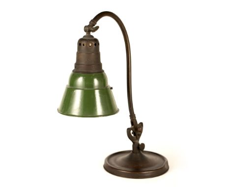 AN OLD BRASS DESK LAMP with circular base and adjustable arm supporting a green enamel decorated shade, the base 21cm diamete