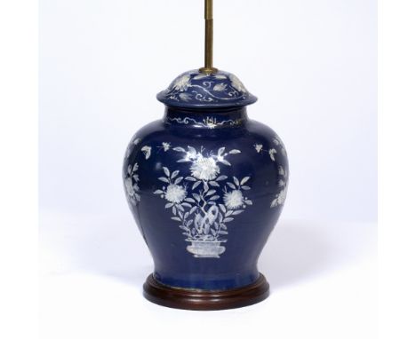 A TABLE LAMP CONSTRUCTED FROM AN ORIENTAL JAR AND COVER with blue ground and white enamel flower decoration on a turned base,