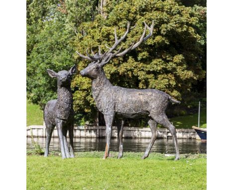 A PAIR OF BRONZE GARDEN SCULPTURES in the form of a stag and a doe, the stag approximately 190cm high x 130cm long overall