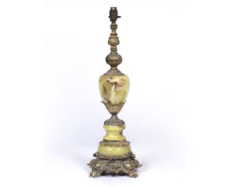 A CAST PARCEL GILT SPELTER AND FAUX ONYX TABLE LAMP with acanthus leaf moulded ornament and scroll feet, 21cm wide x 63cm hig